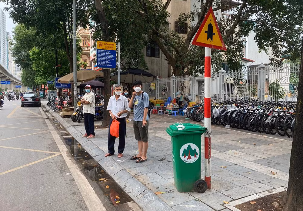 Một thùng rác được “gắn” ngay bên cạnh biển báo giao thông tại quận Hà Đông.