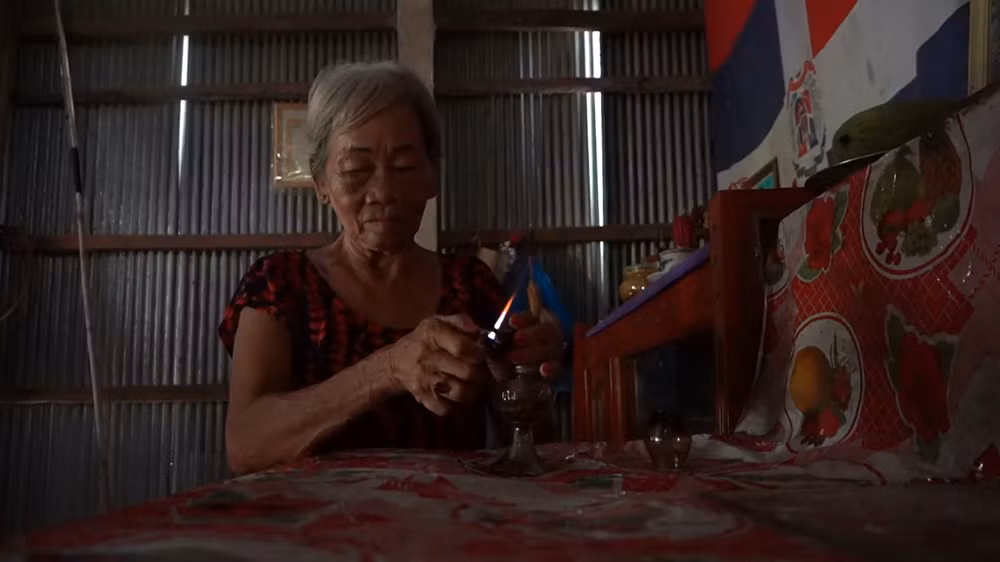 Bà Lê Thị Lời thắp sáng bằng đèn dầu mỗi buổi tối do điện chưa được kéo về tuyến kênh Năm Châu.