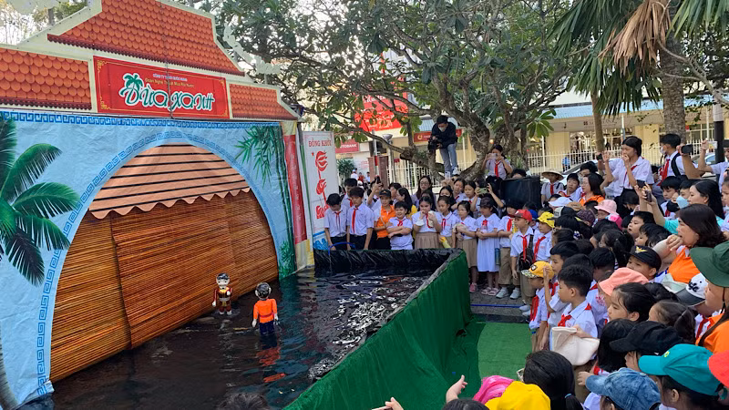 Biểu diễn múa rối nước thu hút đông các em học sinh đến xem.