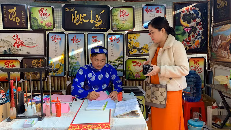 Du khách tham quan gian hàng thư pháp Việt tại Phố ông đồ.