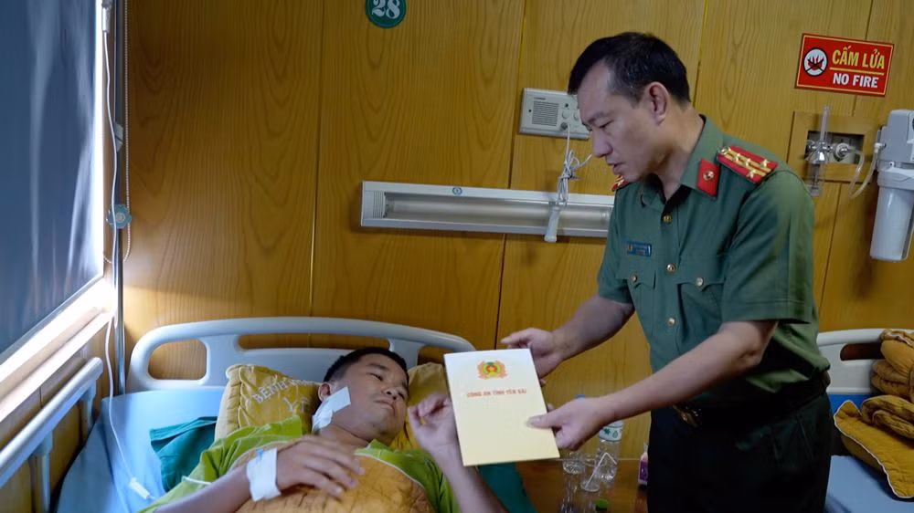 Lãnh đạo Công an tỉnh Yên Bái thăm, động viên thiếu tá Lương Văn Chiến. (Ảnh: THANH SƠN)