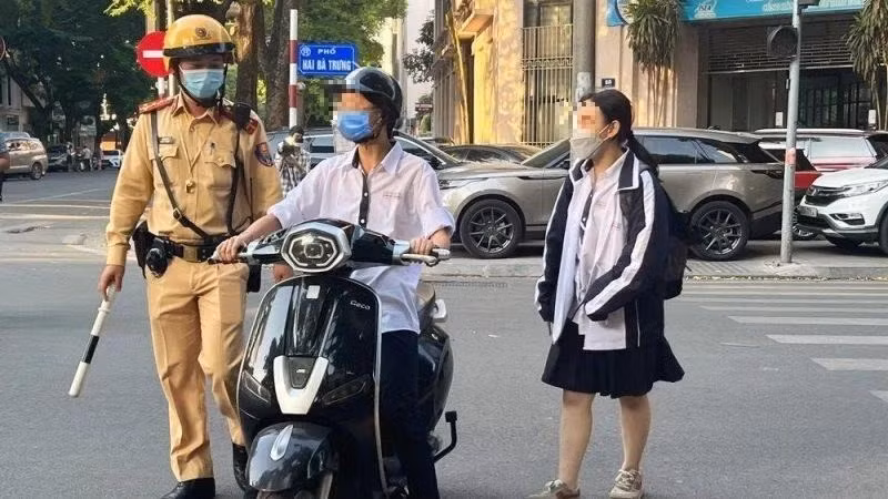 Lực lượng cảnh sát giao thông kiểm tra, xử lý học sinh vi phạm an toàn giao thông của học sinh. (Ảnh: Báo Nhân Dân)