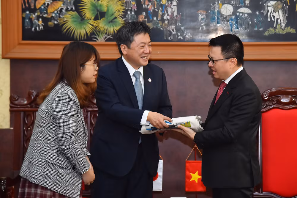 Ông Shimizu Akira, Trưởng đại diện JICA tại Việt Nam nhiệm kỳ từ 3/2020-3/2023 trao món quà là những chiếc túi với hình ảnh các dự án JICA thực hiện tại Việt Nam tặng Tổng Biên tập Báo Nhân Dân Lê Quốc Minh.