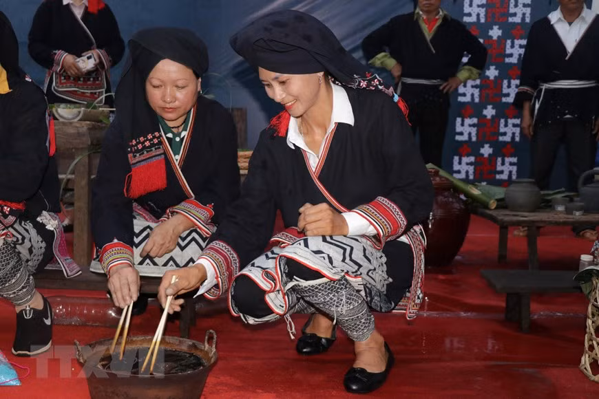 Nghệ nhân người Dao trình diễn nhuộm vải bằng nước chàm. (Ảnh: Hữu Quyết/TTXVN) Nghệ nhân người Dao trình diễn nhuộm vải bằng nước chàm. (Ảnh: Hữu Quyết/TTXVN)
