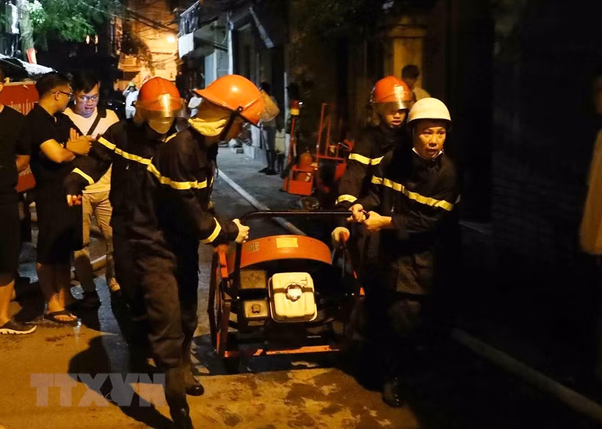 Lực lượng phòng cháy chữa cháy và cứu nạn cứu hộ đưa thiết bị chuyên dụng tiếp cận đám cháy. (Ảnh: Phạm Kiên/TTXVN)