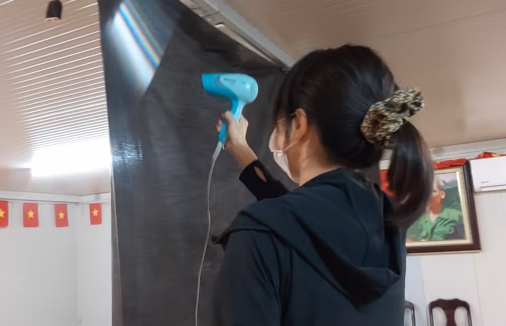 Bác sĩ Huỳnh Thị Thanh Giang đang sấy khô tấm vải phông đen.