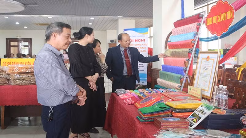 Các đại biểu tham quan gian hàng trưng bày sản phẩm lụa Nha Xá của tỉnh Hà Nam được trưng bày tại hội nghị xúc tiến đầu tư.