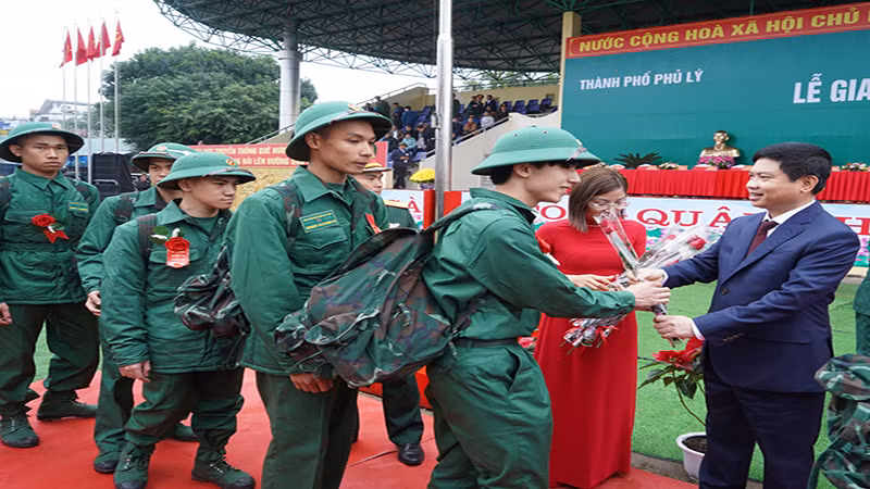 Đồng chí Chủ tịch Ủy ban nhân dân tỉnh Hà Nam tặng hoa, động viên thanh niên lên đường nhập ngũ.