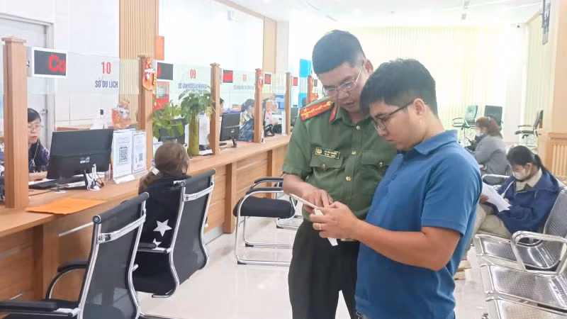 Cán bộ Công an tỉnh hướng dẫn người dân thực hiện thủ tục đề nghị cấp phiếu lý lịch tư pháp qua ứng dụng VNeID trên điện thoại di động.