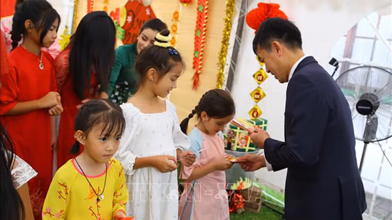 Tặng phong bao lì xì đầu năm cho thiếu nhi Việt Nam tại Nam Phi, nét đẹp truyền thống của đất nước trong những ngày Tết. (Ảnh: TTXVN)