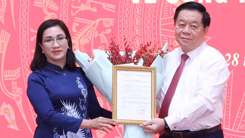 Trưởng Ban Tuyên giáo Trung ương Nguyễn Trọng Nghĩa trao Quyết định cho đồng chí Đinh Thị Mai. (Ảnh: TTXVN)