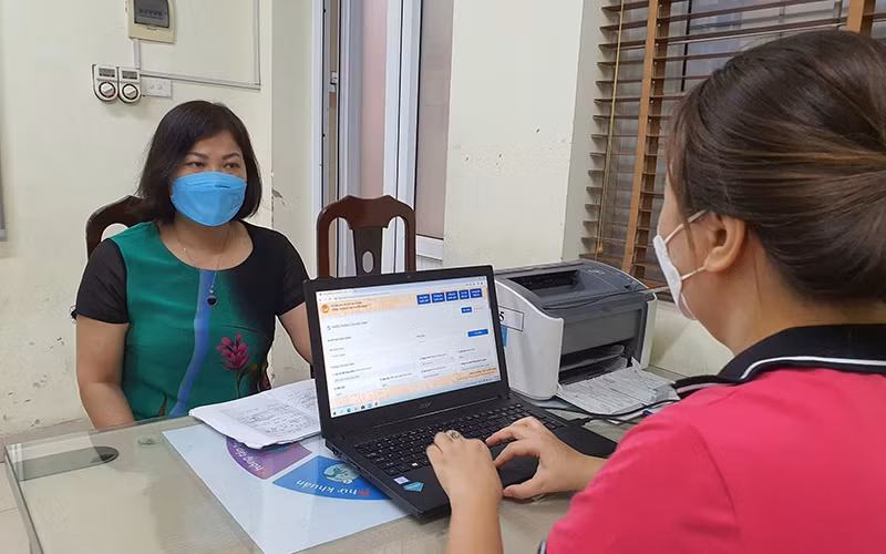 Hỗ trợ phụ huynh đăng ký tuyển sinh trực tiếp tại Trường tiểu học Nghĩa Tân, quận Cầu Giấy, Hà Nội. (Ảnh Thùy Dung)
