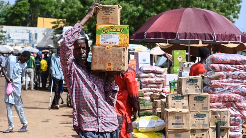 Người dân chuyển lương thực tại khu chợ ở Niamey (Niger). (Ảnh: AFP/TTXVN)