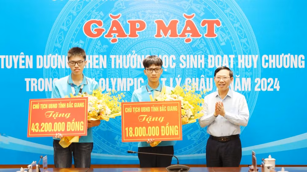 Chủ tịch Ủy ban nhân dân tỉnh Bắc Giang Lê Ánh Dương trao thưởng cho hai học sinh.