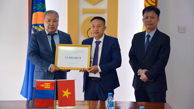 Ông Phạm Quyết Tiến, đại diện cộng đồng người Việt Nam tại Mông Cổ trao khoản tiền quyên góp cho Tổng Cục trưởng NEMA Mông Cổ G.Ariunbuyan trước sự chứng kiến của Đại sứ Việt Nam tại Mông Cổ Doãn Khánh Tâm. (Ảnh: Đại sứ quán Việt Nam tại Mông Cổ)