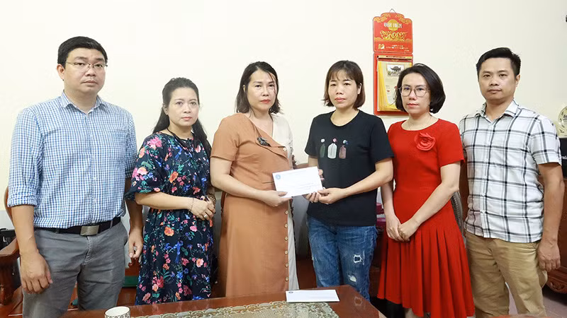 Bảo hiểm xã hội quận Thanh Xuân trao hỗ trợ cho gia đình các nạn nhân trong vụ cháy chung cư mini tại Khương Hạ. (Ảnh: Khánh Duy)