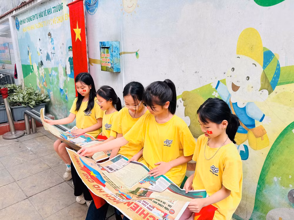 Các em học sinh rất say mê khi được đọc Báo Nhân Dân.