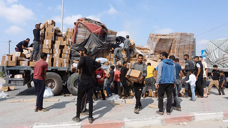 Người dân chuyển hàng cứu trợ nhân đạo tại cửa khẩu Rafah ở Dải Gaza.