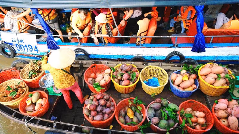 Du khách trải nghiệm cảnh mua bán trái cây trên chợ nổi Cái Răng.
