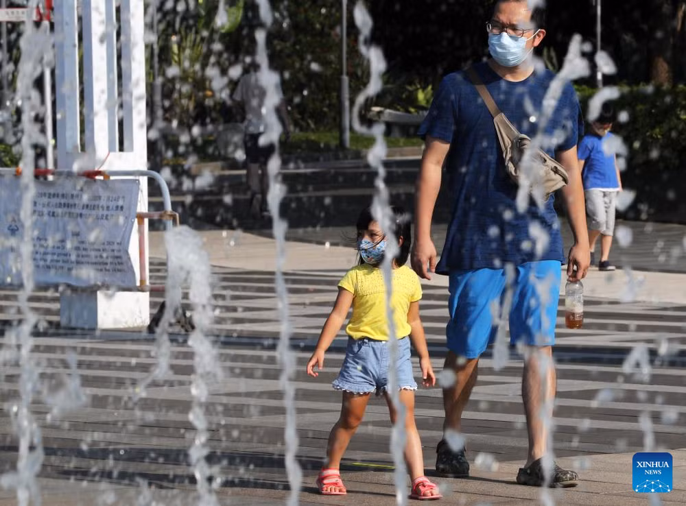 Người dân đi ngang qua đài phun nước vào một ngày hè nóng nực ở Hong Kong, Trung Quốc. Ảnh: Tân Hoa xã