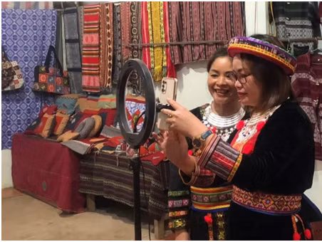 Thành viên Hợp tác xã Thiên An (Bạch Thông) livestream bán hàng thổ cẩm. (Ảnh: LƯU HUỆ)