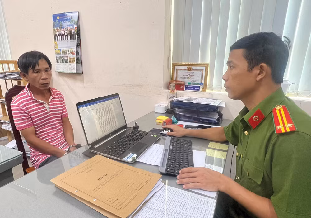 Cán bộ điều tra lấy lời khai nghi can Lê Huy Dũng.