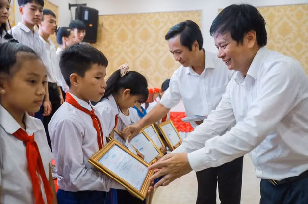 Ông Trần Trọng Dũng, Phó chủ tịch Hội nhà báo Việt Nam, phụ trách phía nam (ngoài cùng bên phải) và ông Hoàng Nam, Phó chủ tịch UBND tỉnh Quảng Trị tặng học bổng cho các em học sinh.