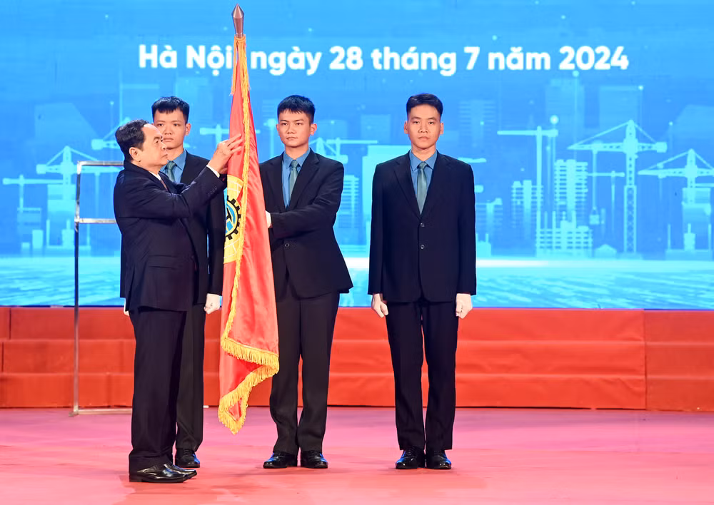 Chủ tịch Quốc hội Trần Thanh Mẫn gắn Huân chương Lao động hạng Nhất lên cờ truyền thống của Tổng Liên đoàn Lao động Việt Nam.