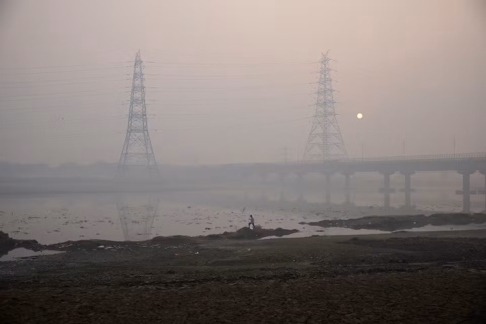 Một người đàn ông đi bộ trên bờ sông Yamuna vào một buổi sáng sương mù ở New Delhi, Ấn Độ. (Ảnh: Reuters)