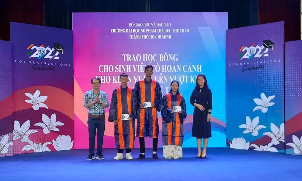 Các nhà tài trợ trao học bổng cho các sinh viên nghèo vượt khó học tập.