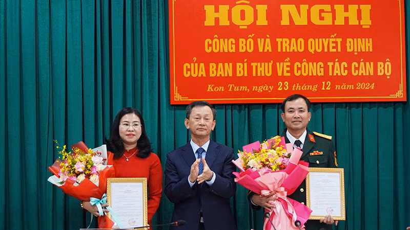 Đồng chí Dương Văn Trang trao Quyết định và tặng hoa 2 đồng chí Trương Thị Linh và Nguyễn Thế Vinh.
