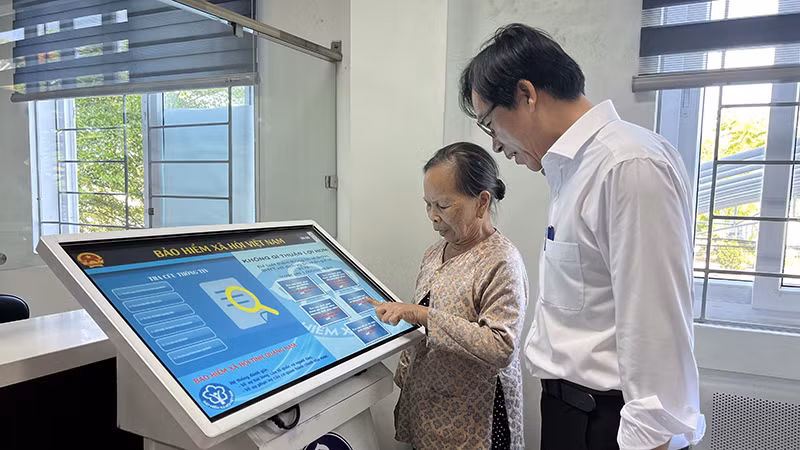 Cán bộ Bảo hiểm xã hội thành phố Hội An, tỉnh Quảng Nam hướng dẫn người dân làm thủ tục bảo hiểm xã hội.