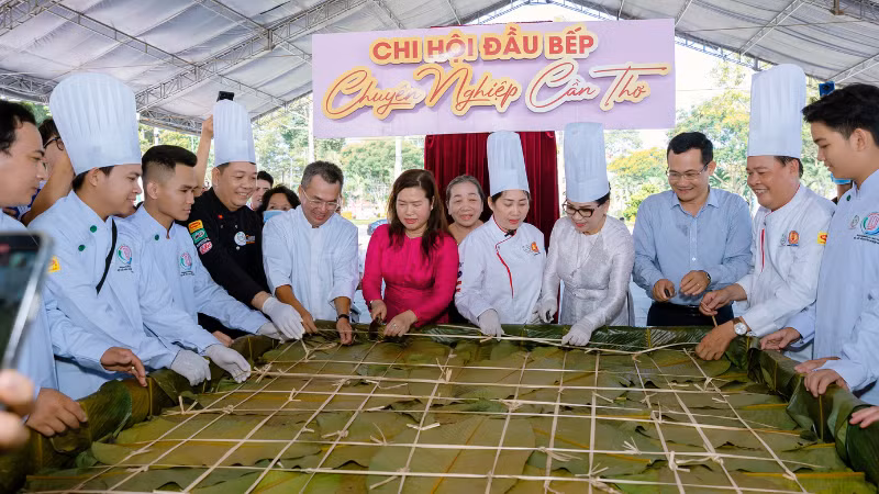 Lãnh đạo thành phố Cần Thơ cùng các nghệ nhân bên chiếc bánh chưng khổng lồ tại lễ hội.