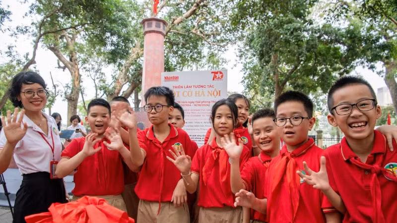 Các em học sinh Trường tiểu học Tràng An thích thú trước mô hình tái hiện Cột cờ Hà Nội. (Ảnh: THÀNH ĐẠT)