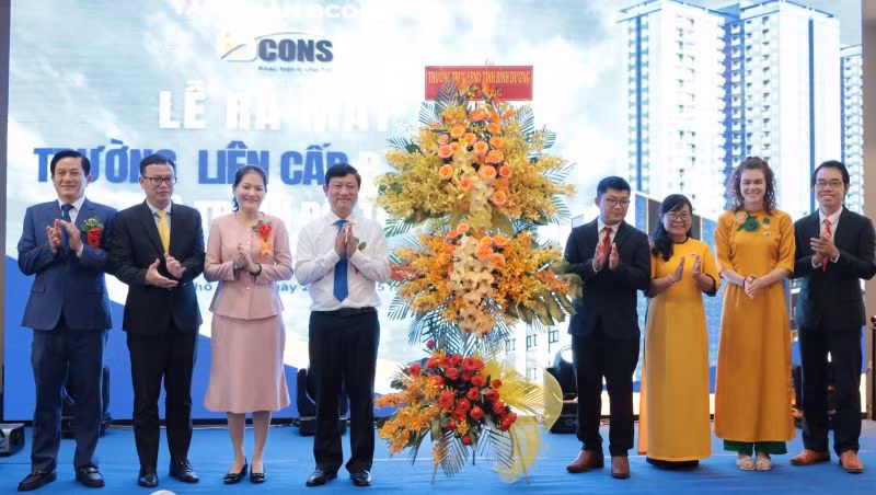 Chủ tịch Ủy ban nhân dân tỉnh Bình Dương Võ Văn Minh (thứ 4 từ trái sang) trao lẳng hoa chúc mừng Trường liên cấp B.School.