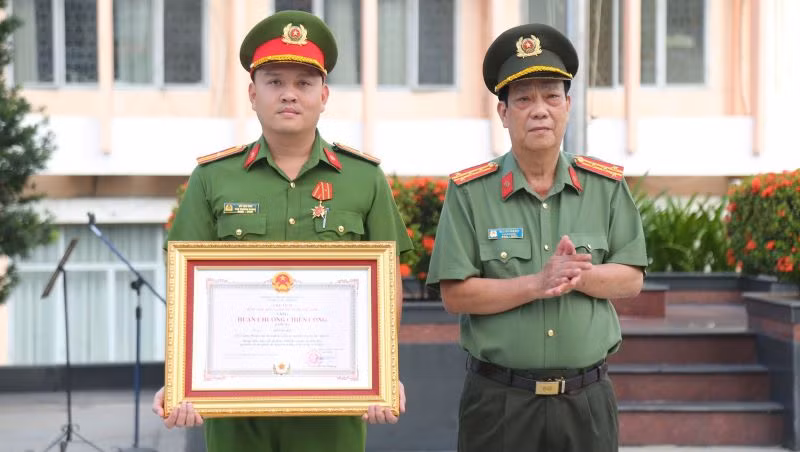 Đại tá Nguyễn Văn Dựt, Phó Giám đốc Công an tỉnh Bình Dương trao tặng Huân chương chiến công hạng Ba cho Thiếu tá Võ Văn Sơn.
