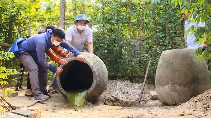 Các lực lượng chức năng trợ giúp hộ dân ở phường Hải Thanh đổ kiệt nước đọng trong các chum.