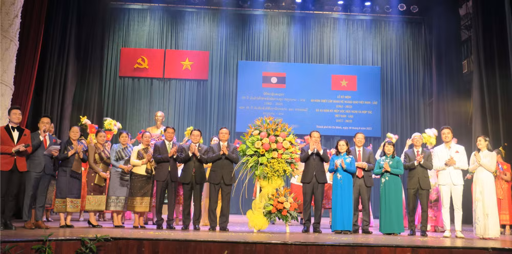 Các đồng chí lãnh đạo Thành phố Hồ Chí Minh và Lào tặng hoa chúc mừng các nghệ sĩ biểu diễn tại Lễ kỷ niệm.