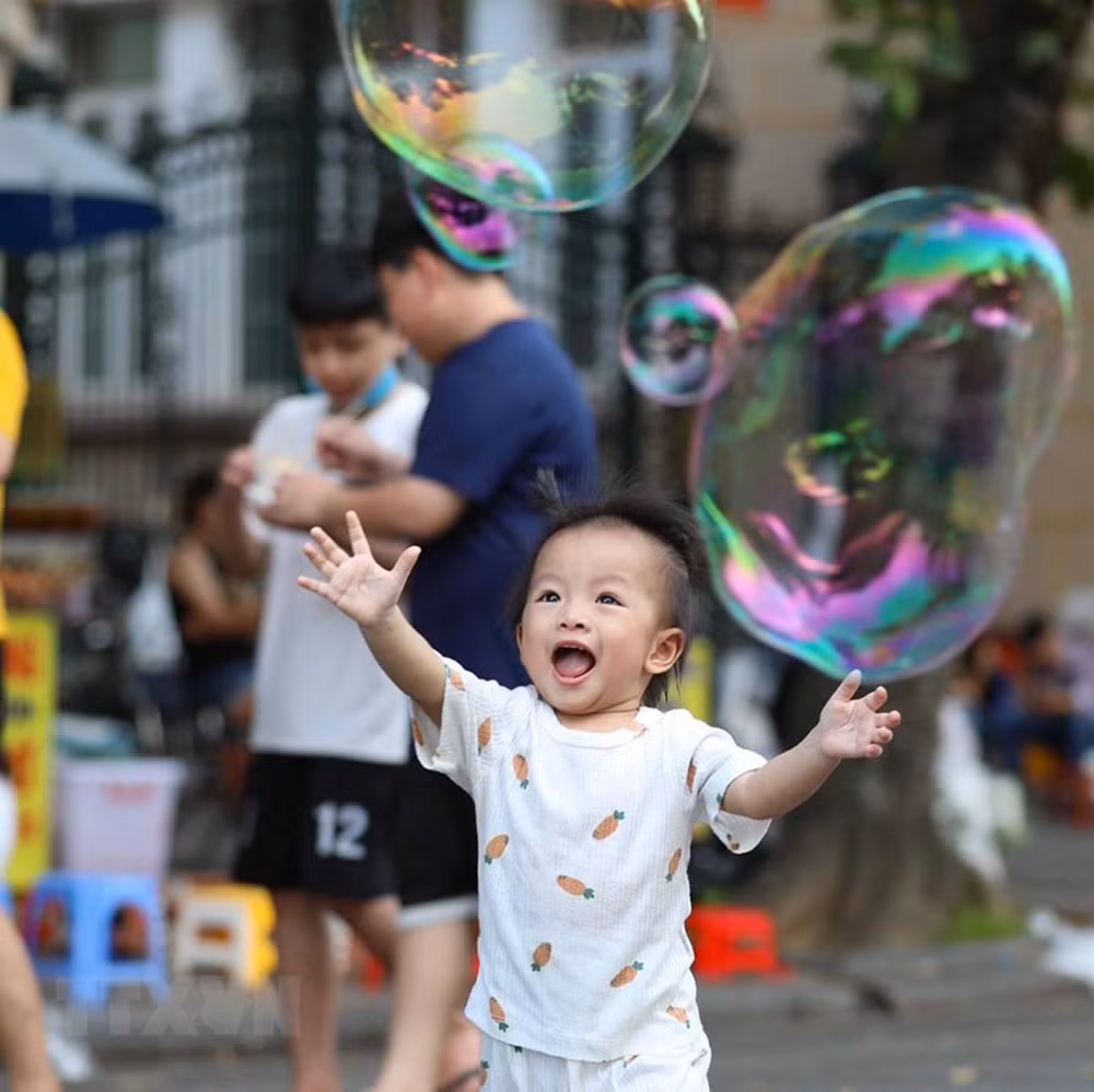 Trẻ em thích thú với bong bóng trong không gian đi bộ hồ Hoàn Kiếm. (Ảnh: Thanh Tùng/TTXVN)