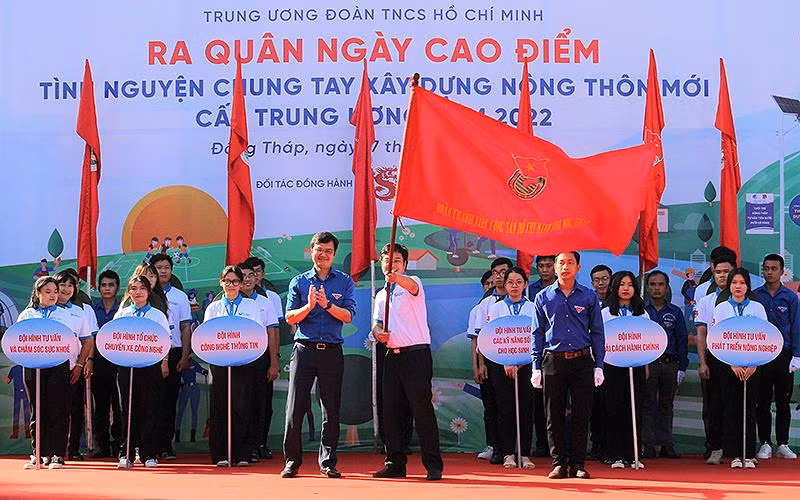 Đồng chí Bùi Quang Huy, Ủy viên dự khuyết Trung ương Đảng, Bí thư Thường trực Trung ương Đoàn (bên trái, hàng đầu) trao cờ tình nguyện cho Đội hình “Trí thức trẻ chuyển giao tiến bộ kỹ thuật” tại xã Tân Kiều (huyện Tháp Mười, tỉnh Đồng Tháp).