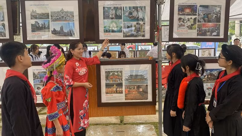 Giới thiệu cho học sinh dân tộc về hình ảnh tại triển lãm.
