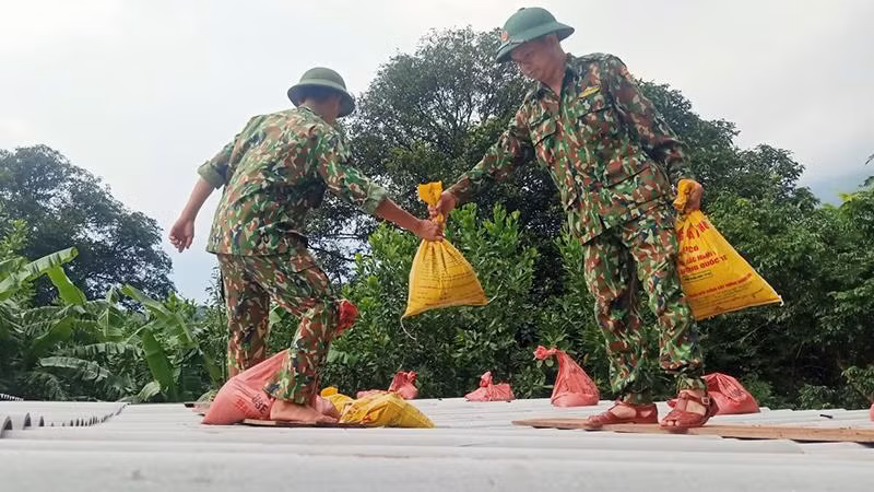 Bộ đội biên phòng gia cố lại mái nhà cho người dân.