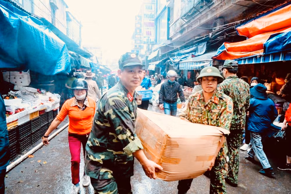 Các lực lượng tập trung hỗ trợ các hộ kinh doanh tại chợ Tam Bạc di chuyển hàng hóa khỏi vụ cháy.