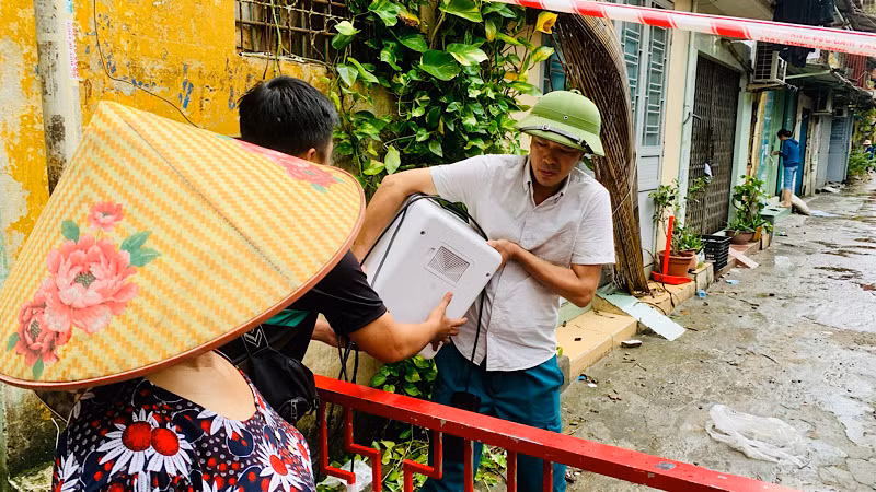 Cán bộ địa phương hỗ trợ người dân tại nhà A8 di chuyển đồ đạc nhỏ lẻ, thiết yếu.