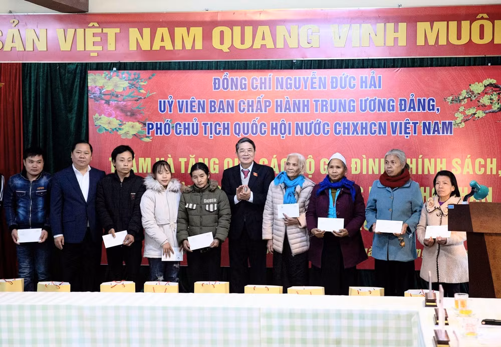 Phó Chủ tịch Quốc hội Nguyễn Đức Hải (giữa) và Bí thư Tỉnh ủy Hòa Bình (thứ 2 từ trái sang) tặng quà Tết cho các gia đình khó khăn.