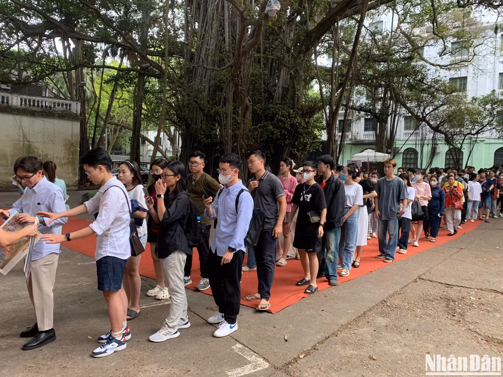 Xếp hàng dài chờ tặng báo Nhân Dân có phụ trương in tranh panorama "Chiến dịch Điện Biên Phủ".