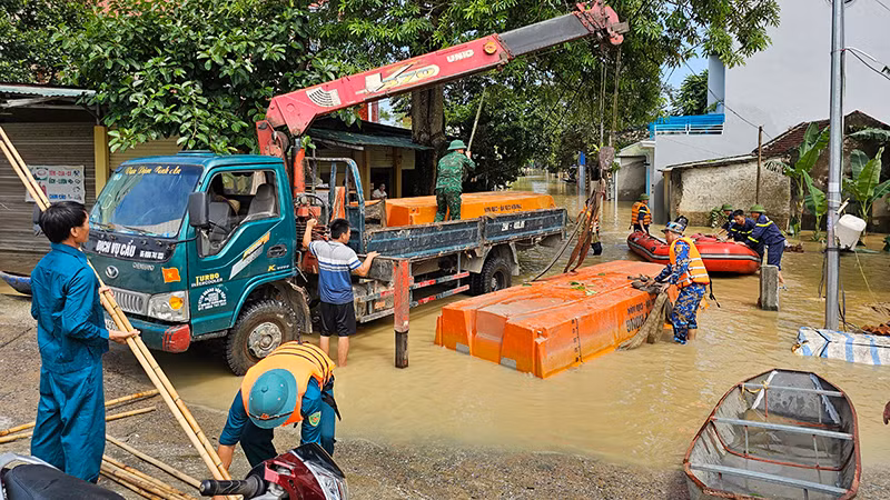 Lực lượng vũ trang hạ thủy phương tiện, hỗ trợ dân vùng ngập lũ di chuyển an toàn.