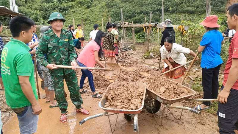 Bộ đội Biên phòng và nhân dân dọn đất, đá sạt lở.