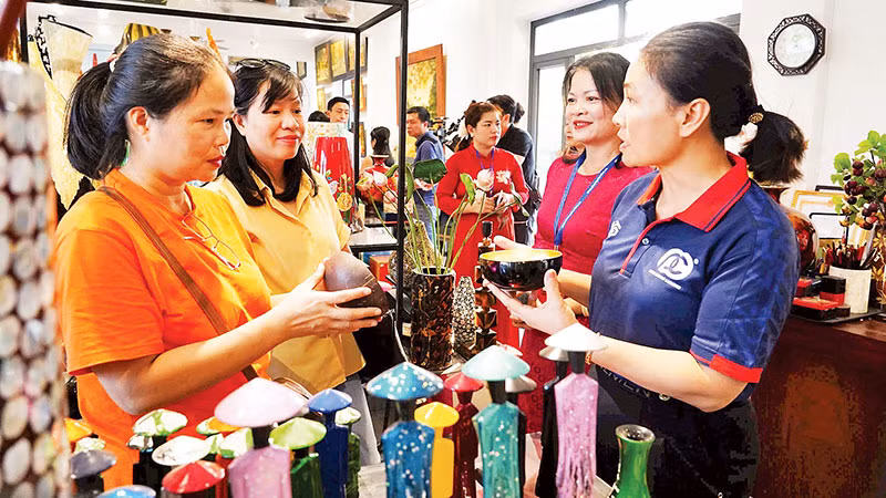 Giang Nam Khách du lịch tham quan gian hàng của làng nghề sơn mài Hạ Thái. (Ảnh Đỗ Minh)