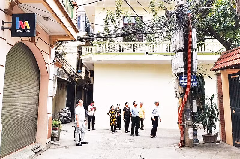 Cán bộ, người dân phường Nghĩa Đô, quận Cầu Giấy giám sát việc lắp đặt camera an ninh trên địa bàn phường. 